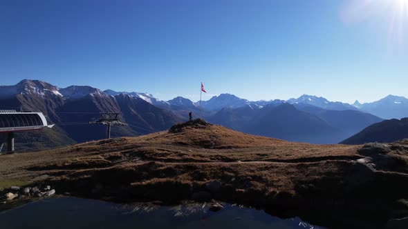 Captivating outlook to panoramic matterhorn and alps with hiker and swiss flag