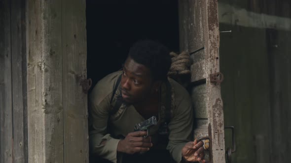 African Man with Gun Leaving Shack Hiding From Zombie in Abandoned Territory