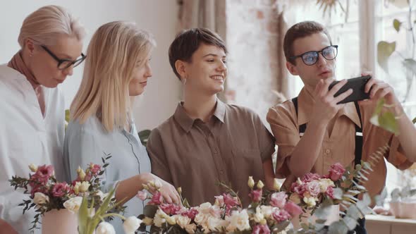 Male Florist Taking Group Selfie with Female Colleagues in Flower Workshop