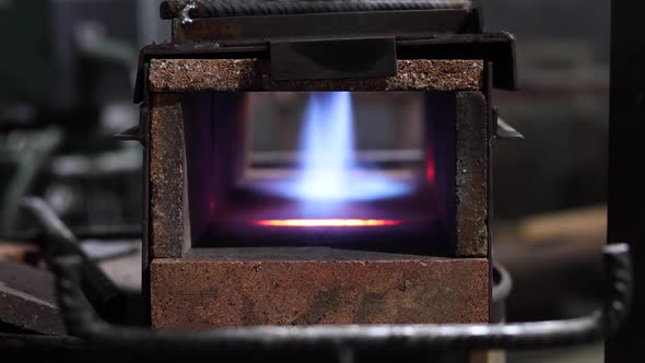 Metal detail burning in furnace in workshop