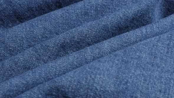 Blue classic denim surface gathers close-up 4K 2160p 30fps UltraHD tilting footage - High quality  j