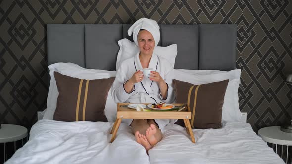 Happy Female in Bathrobe Having Breakfast in Bed