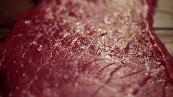 Coarse Sea Salt on the Raw Meat Steak Close Up