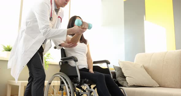 Rehabilitation Doctor Helps Woman in Wheelchair to Do Exercises with Dumbbells Slow Motion  Movie