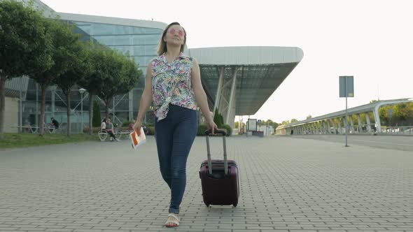 Woman Tourist Walking with Luggage From Airport. Girl Stops and Start Smiling, Rejoices. Vacation