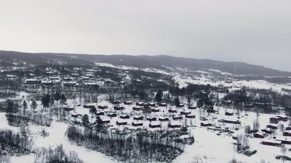 Wide aerial dolly zoom showing small town in white wintery landscape