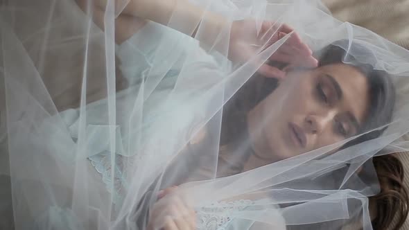 Close-up Shot of a Beautiful and Sexy Bride in the Morning Lying on Bed in Luxurious Turquoise Lacy