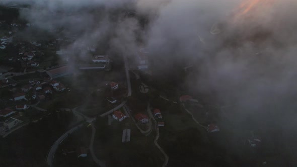 Aerial forward through clouds over Caramulo city at sunrise, Portugal