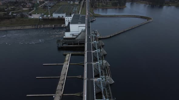 Dolly Out Aerial View Over Cars Passing By Hydroelectric Power Plant in Kegums Latvia Nad River