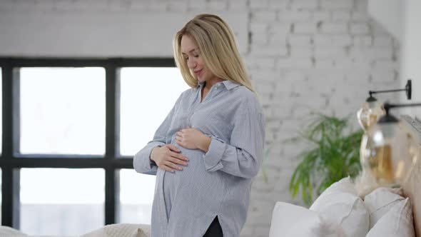 Side View of Happy Pregnant Woman Talking to Unborn Fetus Caressing Belly