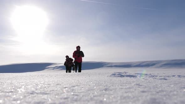 Three Alpinist Tourists Follow Each Other in the Snowy Desert. Teamwork and Victory