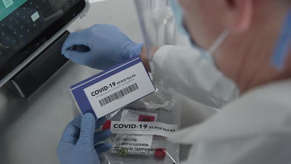 Over the shoulder look of medical personnel working on covid-19 kit