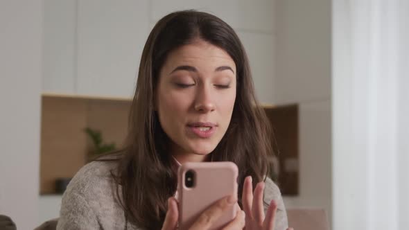 Close Up  Young Caucasian Woman Greeting Her Friends on a Video Call Using Pink Smart Phone