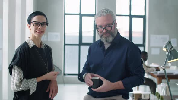 Portrait of Senior Businessman with Cheerful Mid Age Colleague in Office