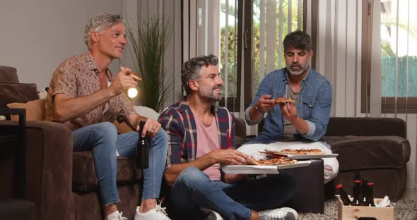 Happy men eating pizza and beer