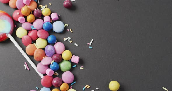 Video of colourful lentils and lollipop on grey background