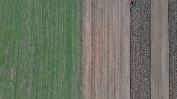 Aerial View of Red Tractor Plowing Field in Autumn