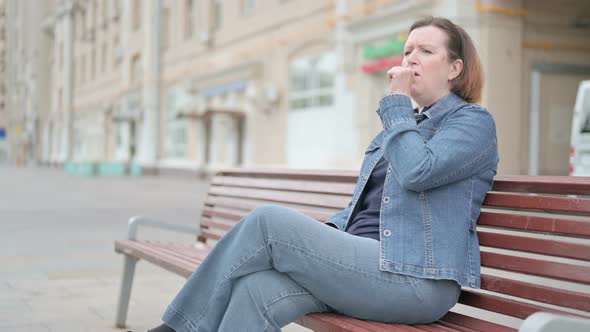 Old Woman Coughing While Sitting on Bench Outdoor