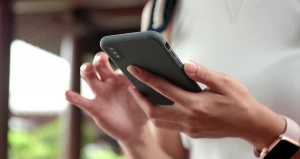 Close up of using mobile phone in Chinese garden