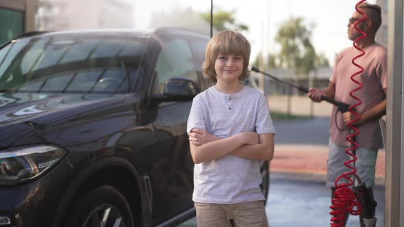 Portrait of Satisfied Caucasian Boy with Crossed Hands Looking at Camera Smiling As Man Turning on