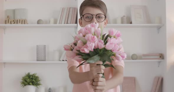 Nerd Little Boy Stretching Bouquet of Flowers To Camera and Smiling, Portrait of Smart Caucasian Kid