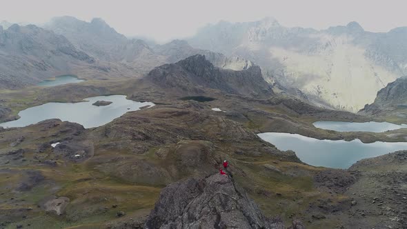 Man Standing on hill Mountains and Lakes From High Altitude