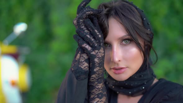 Pretty European Girl in Black Dress and Headscarf Walks Through Streets of the City