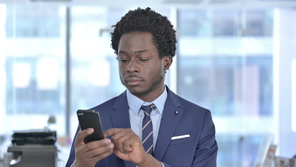 African American Businessman Celebrating Success on Cellphone