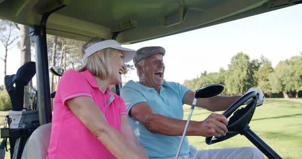 Two golfers driving in their golf buggy