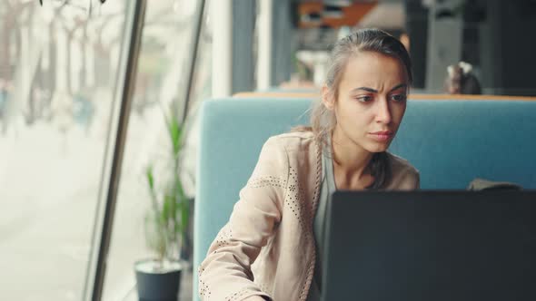Pensive Woman Working Intently at Laptop