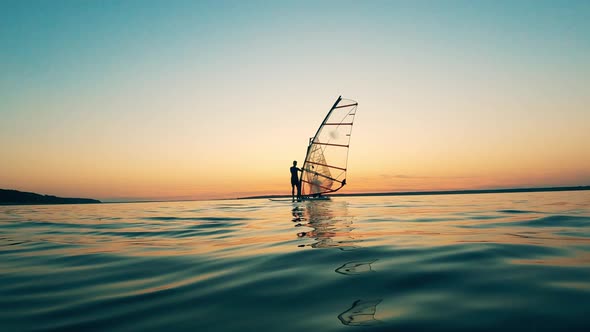 Group of Windsurfers Are Floating in Sunset Waters