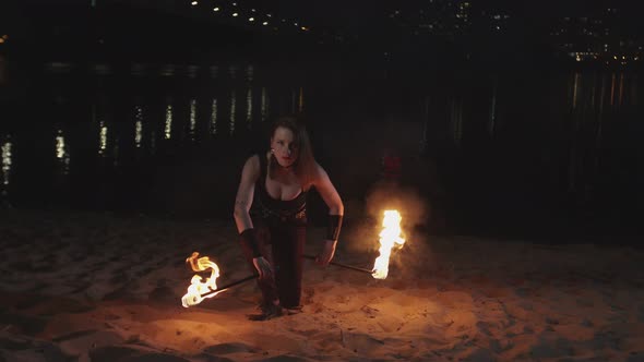 Female Juggler Raising Burning Torches From Sand