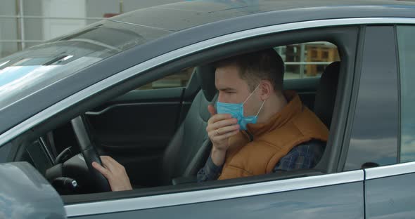 Sick Man in the Car Coughs Sneeze Wearing Protective Face Mask COVID-19 Coronavirus Infection