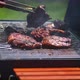 Man Flipping Barbecued Ribs on Coal Grill in His Garden - VideoHive Item for Sale