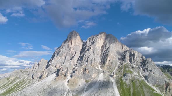 Cloud shadows passing over idyllic South Tyrol Peitlerkofel mountain peak grassy slope aerial view