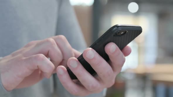 Close Up of Man Browsing Internet on Smartphone