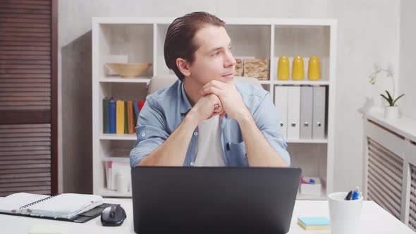 Workplace of freelance worker at home office. Young man works using computer.