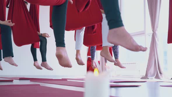 Bare Women Feet Sitting in Antigravity Yoga Hammocks