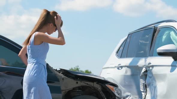 Stressed Driver Talking on Sellphone on Roadside Near Her Smashed Vehicle Calling for Emergency