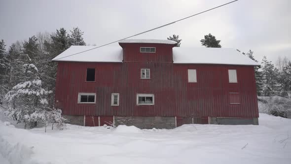 Traditional Red Barn House Amidst Frozen Landscape During Winter In Norway. Pullback Shot