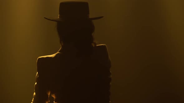 Stylish Sexy Woman Dancing Flamenco Elements in a Dark Smoky Studio in the Rays of Yellow Light