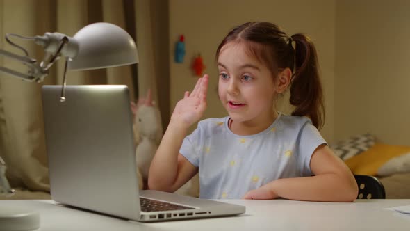 Little Girl Studying at an Online School on a Laptop