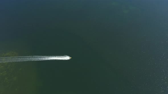 Water scootere away to beach, aerial wide angle shot.