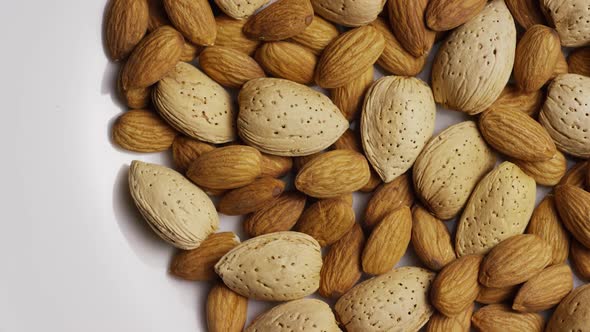 Cinematic, rotating shot of almonds on a white surface - ALMONDS