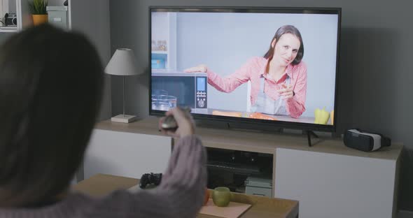 Woman watching a cooking show on TV