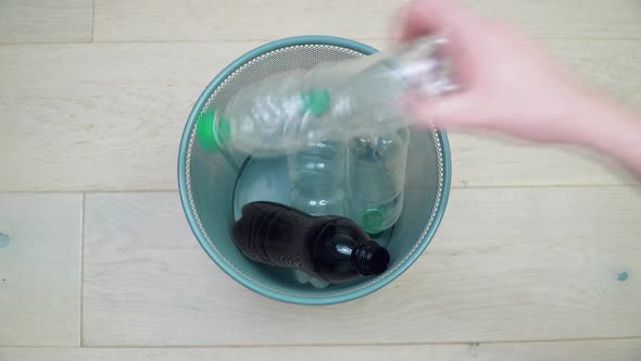 A Man's Hand Takes Turns Picking Up Five Plastic Bottles of Different Colors and Volumes From the