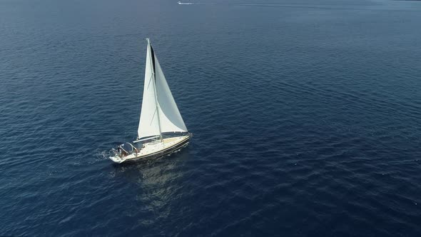 Aerial view of a sailboat driving in the mediterranean sea, Vathi, Greece.