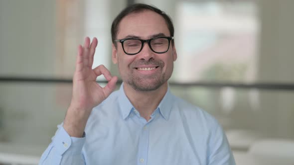 Portrait of Positive Middle Aged Man Showing OK Sign