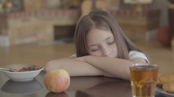 Portrait of Cute Sleeping Kid. Food on the Table and Small Girl with Long Hair Sleeping on It