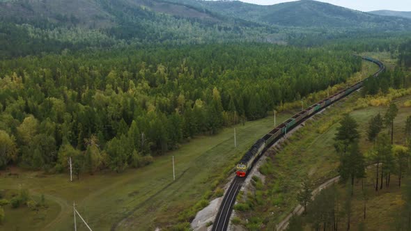 A Cargo Train Is Carrying Coal Through the Woods